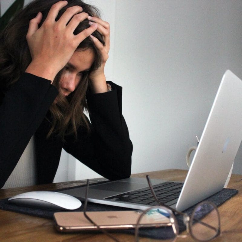 digital marketing strategy is frustrating an employee in front of her laptop and phone at her desk